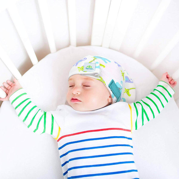 Baby use Tortle repositioning beanie to treat flat head syndrome cause by preference to sleep on one side